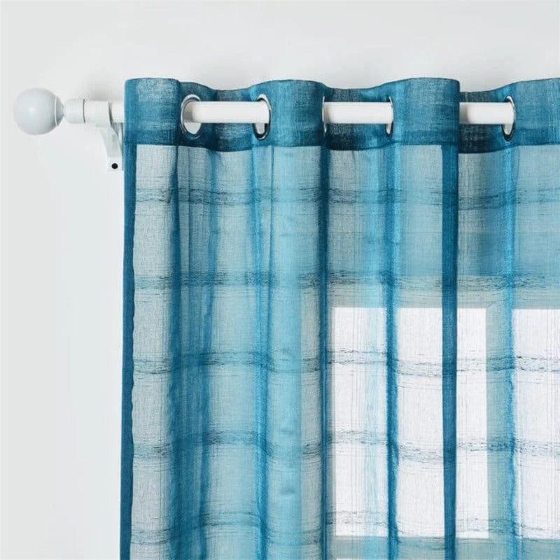 Rideau à œillets bleu translucide, parfait pour filtrer doucement la lumière tout en ajoutant une touche moderne à votre intérieur. Ce modèle allie élégance et fonctionnalité, idéal pour une ambiance apaisante et contemporaine.