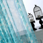 Voilage bleu avec motif floral, idéal pour décorer la maison. Charmante transparence offrant une ambiance lumineuse et élégante. Parfait pour ajouter une touche décorative au salon ou à la chambre.