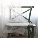 Chaise élégante avec un dossier croisé et un voile délicat, parfaite pour une ambiance romantique dans une salle à manger ou un salon. Design raffiné idéal pour une décoration intérieure chic et épurée.