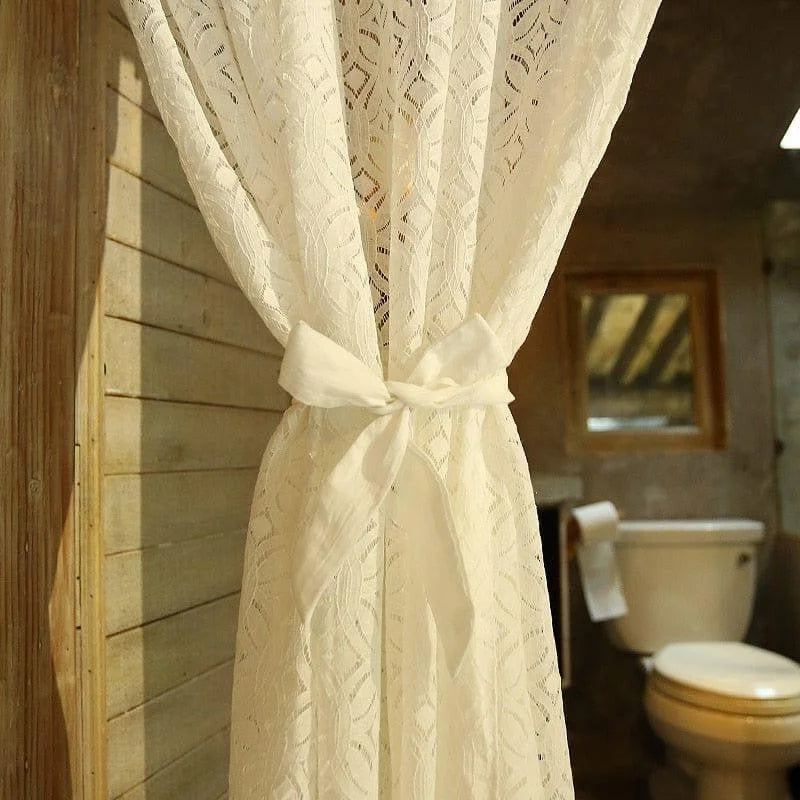 Voilage élégant blanc avec motif décoratif, idéal pour la décoration intérieure d'une salle de bain accueillante. Le rideau est attaché avec un nœud délicat, ajoutant une touche de charme à votre espace. Spa domestique et design raffiné.