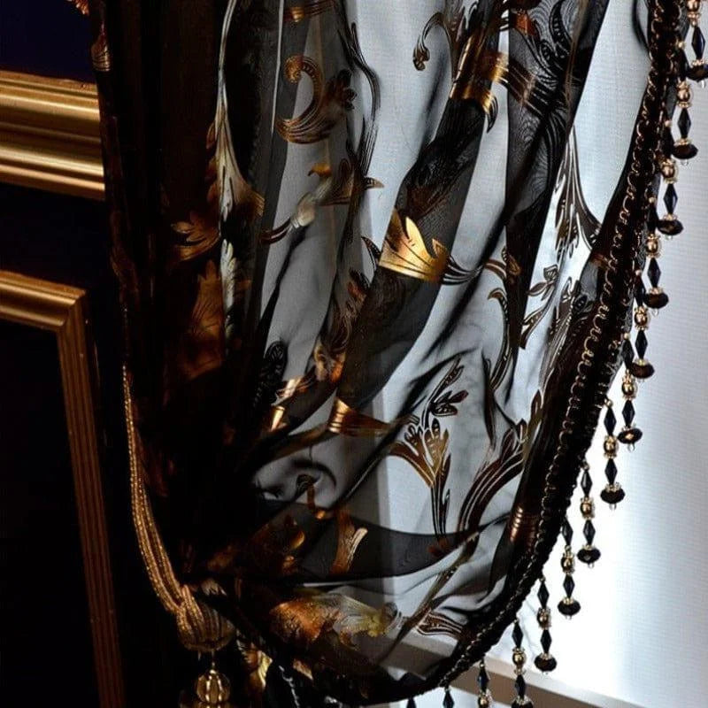 Voilage noir élégant avec motifs dorés et perles en bordure, idéal pour une décoration intérieure raffinée, ajoutant une touche de luxe et de sophistication à votre salon ou chambre. Excellent choix pour créer une ambiance chaleureuse et opulente. Parfait pour les amateurs de design d'intérieur recherchant un élément distinctif et chic.