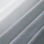 Tissu gris et blanc en gros plan, présentant des plis élégants. Parfait pour des créations de mode ou d'intérieur, ce textile offre une esthétique moderne et épurée. L'alternance des teintes apporte une dimension sophistiquée et intemporelle à vos projets de couture et décoration.