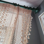 "Rideau élégant au design ajouré et décoratif, suspendu à une tringle verte dans un intérieur moderne. Idéal pour apporter une touche de charme et de lumière naturelle à votre salon ou chambre à coucher."