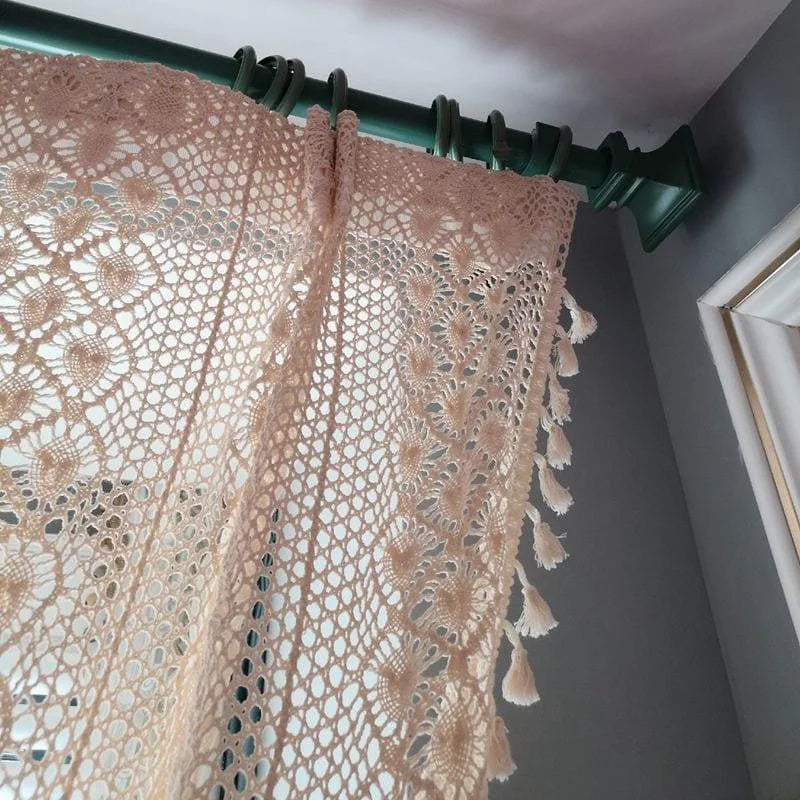 "Rideau élégant au design ajouré et décoratif, suspendu à une tringle verte dans un intérieur moderne. Idéal pour apporter une touche de charme et de lumière naturelle à votre salon ou chambre à coucher."