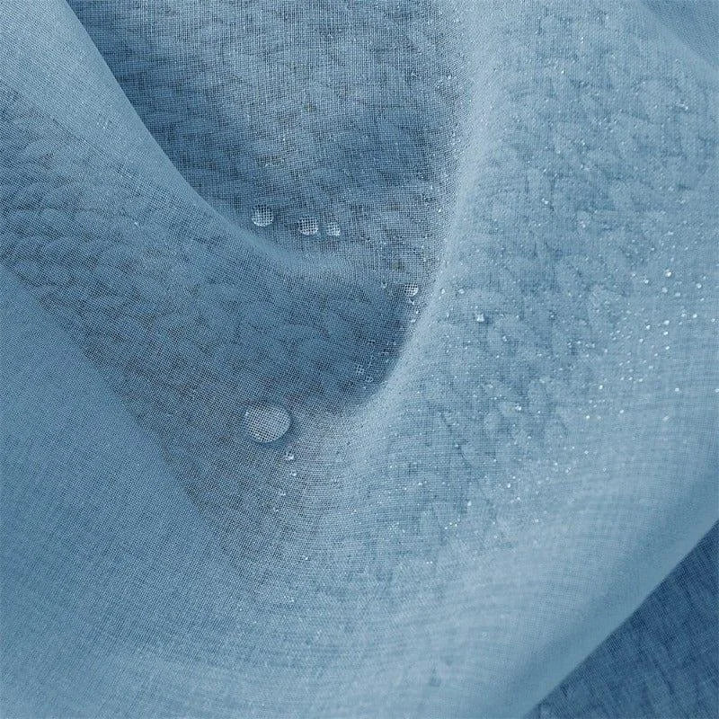 Tissu bleu imperméable avec gouttelettes d'eau.