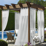 Pergola élégante avec voilages blancs et mobilier d'extérieur, idéale pour créer un espace détente près de la piscine. Profitez d'un cadre paisible alliant confort et style dans votre jardin ou sur votre terrasse. Cette installation offre à la fois intimité et ouverture sur la nature environnante, parfaite pour les moments de relaxation en plein air.