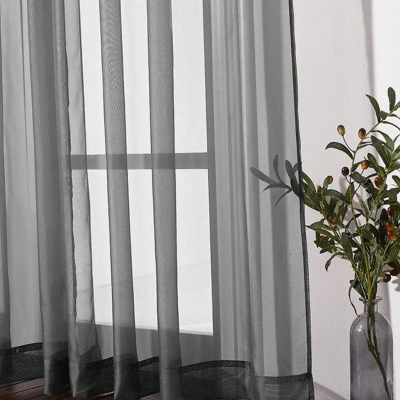 Rideau transparent gris moderne pour salon, ajout élégant et discret à la décoration intérieure. Touche contemporaine idéale pour laisser entrer la lumière tout en préservant l'intimité. Parfait pour salon, chambre ou bureau. Élément de design minimaliste s'harmonisant avec diverses tendances déco. Option idéale pour créer une atmosphère lumineuse et apaisante.