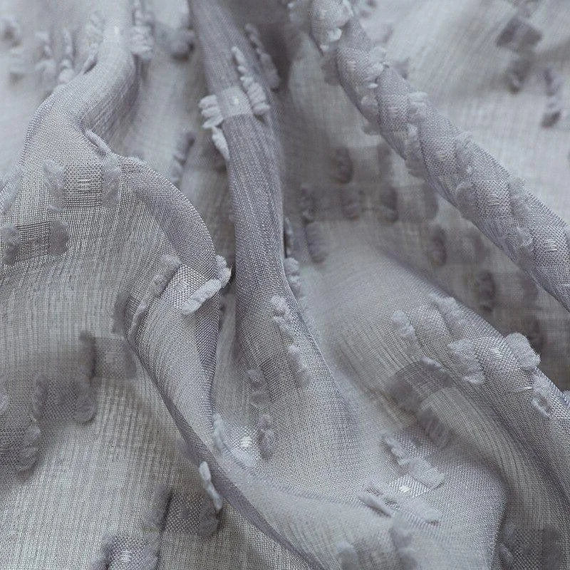 Texture délicate et élégante d'un tissu gris clair avec motifs subtils, idéal pour les créations de mode sophistiquées ou pour apporter une touche raffinée à votre décoration intérieure. Ce tissu offre un effet visuel captivant grâce à ses détails texturés uniques. Parfait pour les designers à la recherche d'un matériau distinctif et stylé.