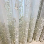 Voilage brodé floral raffiné pour une décoration intérieure élégante. Rideau transparent avec motifs floraux délicats, parfait pour filtrer la lumière tout en ajoutant une touche de sophistication à votre espace de vie. Idéal pour les salons, chambres ou salles à manger. Créez une ambiance lumineuse et chaleureuse avec ce rideau orné.
