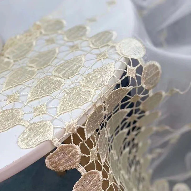 Image d'une nappe décorative avec broderie fine beige et motifs élégants, idéale pour sublimer une table de réception ou un dîner raffiné. Accessoire de décoration sophistiqué pour salon, mariages ou événements spéciaux. Design ajouré contemporain pour une touche d'élégance intemporelle.