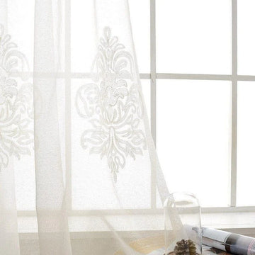 Rideaux élégants brodés pour salon ou chambre à coucher, offrant une ambiance lumineuse et apaisante. Décoration intérieure raffinée avec motifs floraux délicats, parfaite pour un style classique et sophistiqué. Idéal pour filtrer la lumière naturelle tout en préservant l'intimité.