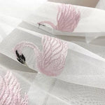 Image d'un élégant tissu décoratif avec motif de flamant rose brodé, idéal pour ajouter une touche de raffinement et de style unique aux projets de décoration d'intérieur ou pour la confection de rideaux et tentures délicates.