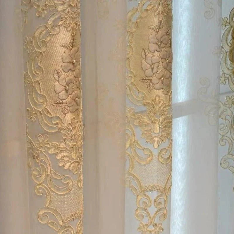 Voilage élégant avec broderies florales dorées, idéal pour ajouter une touche de sophistication à tout intérieur. Ses motifs délicats embellissent la lumière naturelle, créant une ambiance chaleureuse et raffinée. Parfait pour le salon ou la chambre à coucher. Adapté aux décors classiques et modernes. Facile à assortir avec d'autres éléments de décoration intérieure.