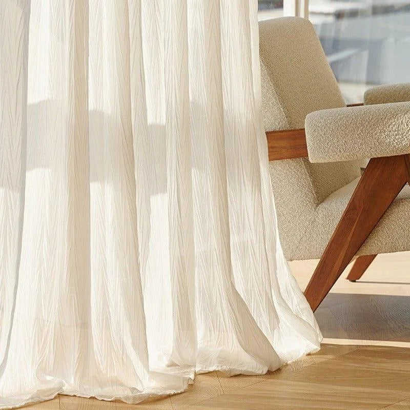 Rideaux blancs élégants laissant entrer la lumière naturelle dans un salon moderne, idéals pour une décoration intérieure sophistiquée, accompagnés d’un fauteuil confortable en bois au design contemporain.