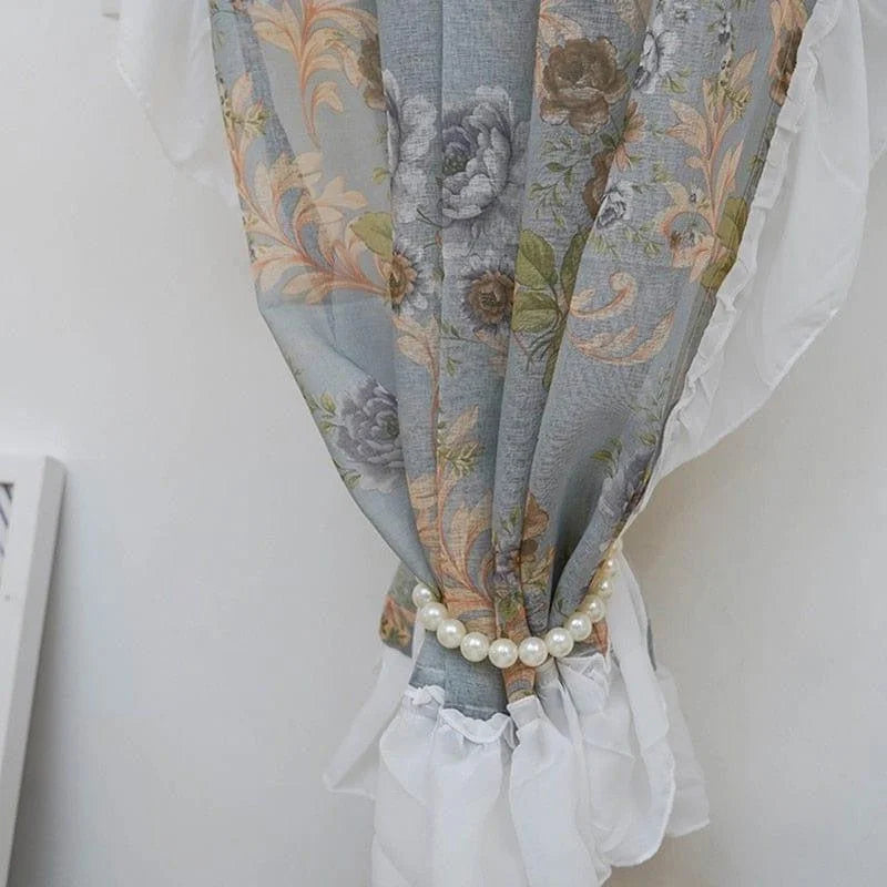 Rideau fleur bleue avec motif floral élégant, idéal pour ajouter une touche de sophistication à la décoration intérieure. Accessoire de maintien perlé, parfait pour une ambiance chic et raffinée dans le salon ou la chambre. Décoration murale élégante et tendance.