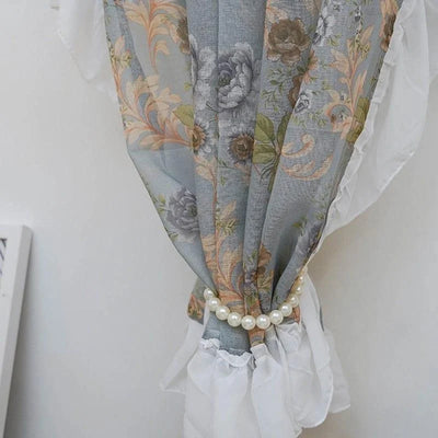Rideau fleur bleue avec motif floral élégant, idéal pour ajouter une touche de sophistication à la décoration intérieure. Accessoire de maintien perlé, parfait pour une ambiance chic et raffinée dans le salon ou la chambre. Décoration murale élégante et tendance.