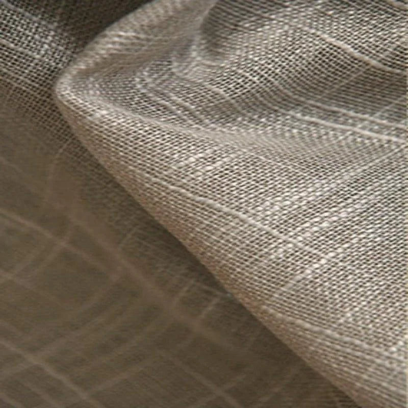 Gros plan sur un tissu naturel de couleur beige avec un motif de tissage fin, idéal pour la confection de rideaux élégants ou de vêtements légers. Ce tissu offre une texture douce et respirante, parfaite pour ajouter une touche de sophistication à toute pièce. Choix parfait pour les projets de couture artisanale.