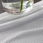 Tissu à motif zigzag noir et blanc sous un vase en verre, idéal pour ajouter une touche moderne et élégante à votre décoration intérieure. Parfait pour des projets de couture ou de design d'intérieur nécessitant une esthétique contemporaine.