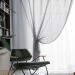 Fauteuil design moderne avec accoudoirs en bois, placé devant une grande fenêtre avec rideaux élégants, ajoutant une touche de sophistication à un intérieur contemporain. Décoration idéale pour un salon chaleureux et stylé.