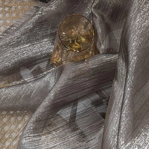 Verre élégant posé sur un magnifique tissu argenté, créant une ambiance chic et lumineuse pour des occasions spéciales ou une décoration intérieure raffinée. Ce produit allie style et sophistication, idéal pour sublimer votre table.