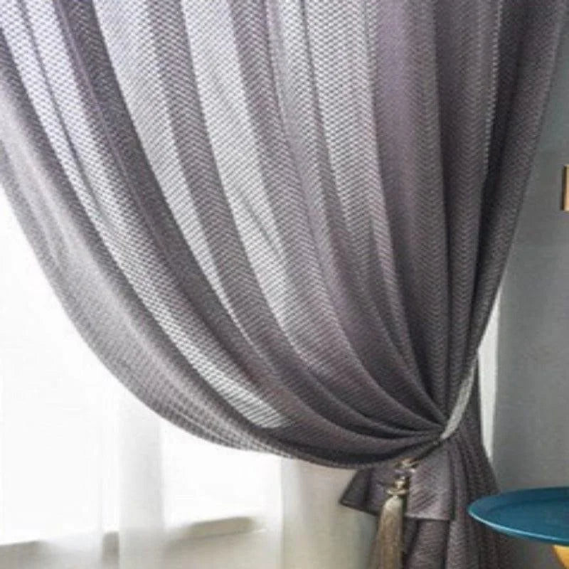 Rideau gris élégant pour salon moderne, suspendu à une fenêtre, offrant une ambiance chaleureuse. Idéal pour décorer votre intérieur tout en contrôlant la lumière. Accessoire chic pour un aménagement d'intérieur raffiné.