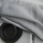 Voilage gris élégant avec motifs texturés, idéal pour apporter une touche moderne et lumineuse à votre intérieur. Convient parfaitement aux salons ou chambres contemporaines. Accessoirisé avec une vaisselle noire design pour un contraste chic et minimaliste.