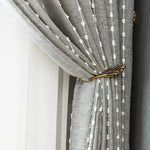 Rideau élégant gris avec motifs à rayures en relief, fixation en métal doré ornementale, design moderne pour une décoration intérieure sophistiquée. Idéal pour embellir votre salon ou chambre avec une touche contemporaine et chic.
