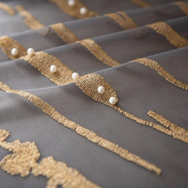 Tissu décoratif élégant avec motifs dorés et perles, idéal pour la décoration intérieure. Ce drapé raffiné apporte une touche de luxe et de sophistication à tout espace. Les détails dorés ajoutent un effet visuel attrayant, parfait pour créer une atmosphère chic dans un salon ou une chambre.