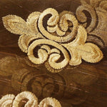 Broderie élégante avec motif doré sur fond marron, apportant une touche sophistiquée et décorative pour un intérieur raffiné. Design ornemental idéal pour embellir les textiles d'ameublement ou les accessoires de décoration.