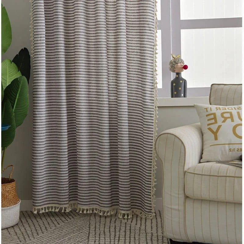 Rideau rayé élégant avec franges, accroché dans un salon moderne. Idéal pour apporter une touche de style et d'intimité à votre espace de vie. Parfait pour compléter une décoration intérieure soignée et contemporaine.