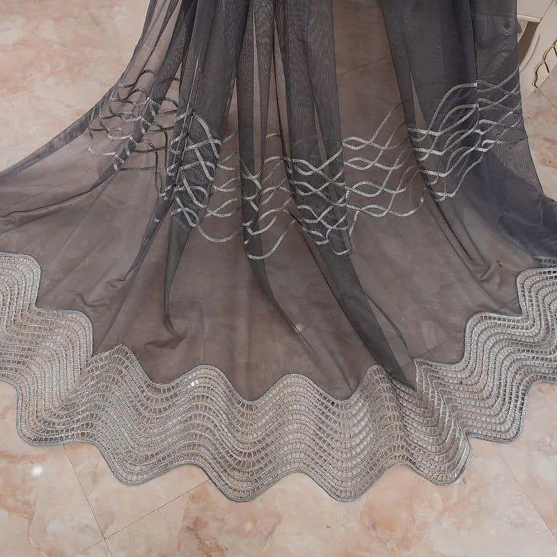 Voilage de luxe gris avec motifs brodés, parfait pour ajouter une touche élégante à votre intérieur. Idéal pour le salon ou la chambre, ce rideau raffiné offre un design attrayant avec des motifs ondulés et des détails délicats. Ajoutez une ambiance sophistiquée à votre espace de vie avec cet accessoire de décoration chic.