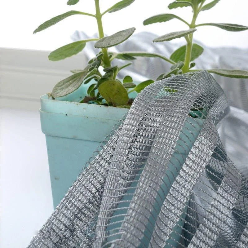Pot de plantes vertes avec voile de protection pour jardinage intérieur et extérieur. Idéal pour préserver les fleurs et les arbustes, ce filet est parfait pour réguler l'exposition au soleil et assurer une croissance optimale. Accessoire de choix pour les amateurs de jardinage recherchant une solution efficace et esthétique.