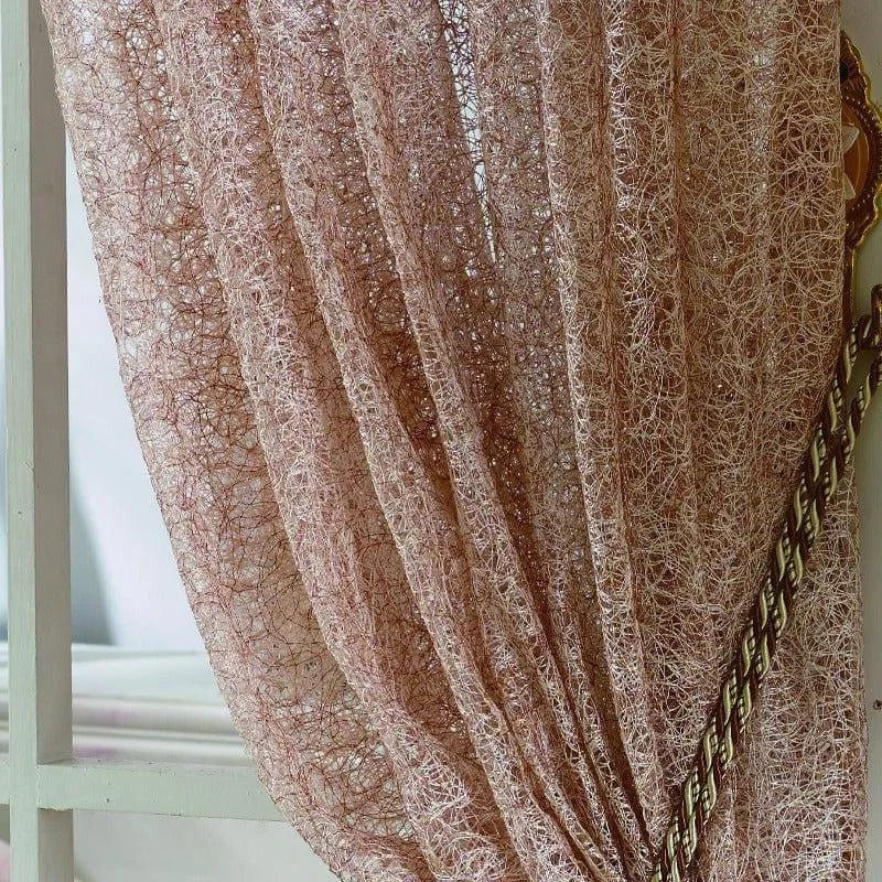 Rideau décoratif rose suspendu à une fenêtre avec embrasse élégante, offrant un aspect texturé unique et subtilement ajouré. Parfait pour apporter une touche moderne et sophistiquée à votre intérieur.