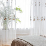 Voilage blanc avec motifs floraux, idéal pour ajouter une touche élégante et lumineuse à votre intérieur. Parfait pour une chambre ou un salon, il filtre doucement la lumière tout en préservant l'intimité. Plante d'intérieur en pot ajoutant une ambiance naturelle et relaxante à votre espace. Style moderne et épuré.