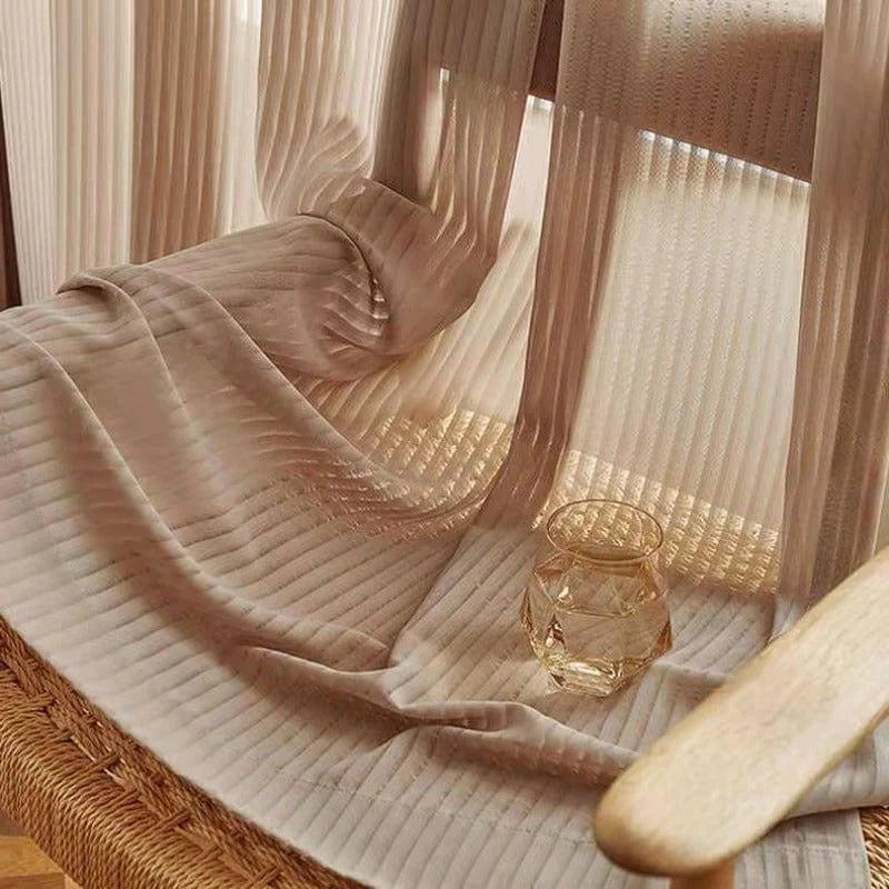 Rideau transparent beige offrant une ambiance chaleureuse et douce pour votre intérieur, parfait pour tamiser la lumière du jour tout en ajoutant une touche élégante et moderne à votre décoration. Idéal pour le salon ou la chambre, ce rideau combine esthétique et fonctionnalité pour créer un espace accueillant.