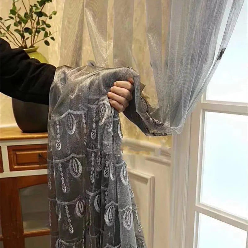 Rideau décoratif élégant suspendu près d'une fenêtre, mettant en valeur un motif complexe qui ajoute une touche sophistiquée à votre intérieur. Parfait pour sublimer votre salon ou chambre à coucher, ce rideau allie design moderne et raffinée. Idéal pour transformer l'atmosphère de votre maison avec style.