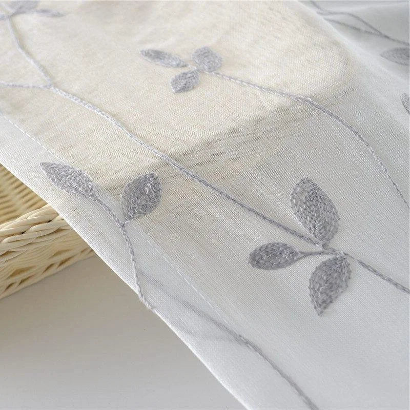 Voilage décoratif aux motifs floraux subtils gris, idéal pour apporter une touche élégante et raffinée à votre intérieur. Parfait pour habiller vos fenêtres tout en laissant passer la lumière naturelle.