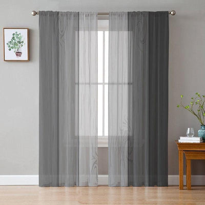 Rideaux transparents gris élégants pour salon, installation sur tringle métallique, déco intérieure moderne, ambiance sobre et lumineuse, pièce bien éclairée avec plantes vertes et mobilier en bois.
