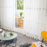 Rideaux décoratifs blancs avec motifs colorés, ajoutant une touche élégante à un salon moderne. Idéals pour créer une atmosphère lumineuse et aérée, ces rideaux embellissent l'espace tout en préservant l'intimité. Parfaits pour une décoration intérieure contemporaine, ils s'intègrent harmonieusement avec divers styles de meubles et accessoires.