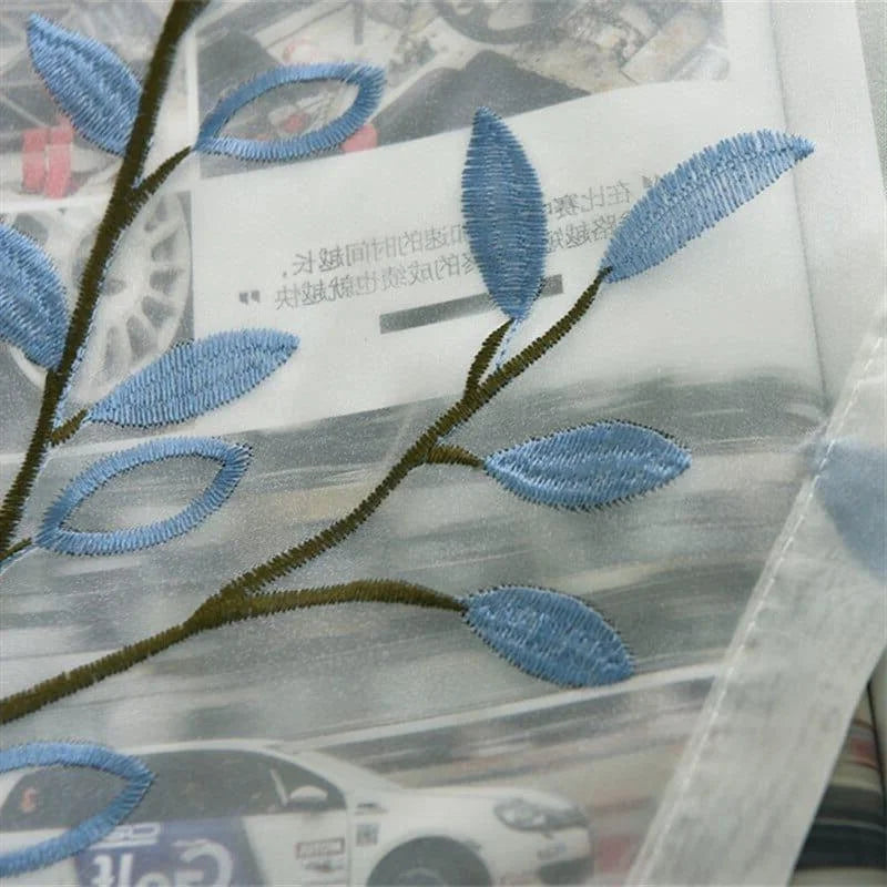 Image d'un élégant rideau brodé avec un motif de branchage et feuilles bleues, idéal pour ajouter une touche naturelle et raffinée à votre intérieur. Ce rideau est conçu pour s'harmoniser avec divers styles de décoration, offrant à la fois esthétisme et fonctionnalité pour embellir votre espace de vie.