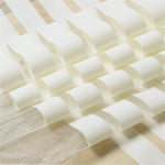 Voilage doux à rayures blanches et beiges pour décoration intérieure élégante. Tissu léger idéal pour filtrer la lumière tout en préservant l'intimité. Design moderne et raffiné, parfait pour salons et chambres.