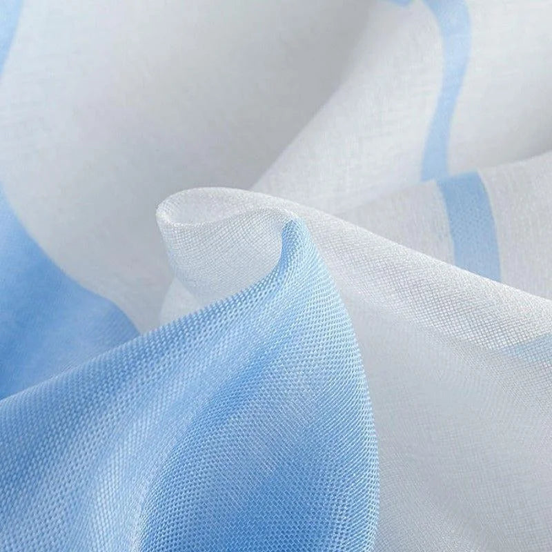 Voile décoratif en teinte bleue et blanche, idéal pour une touche élégante et légère dans la décoration intérieure. Design fluide et moderne, parfait pour embellir les fenêtres ou les espaces de vie avec une ambiance douce et apaisante.