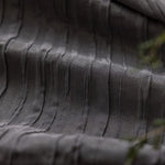 Texture élégante d'un tissu gris foncé avec motifs en relief, parfait pour la décoration d'intérieur ou la confection de vêtements sophistiqués. Découvrez ce design unique et moderne pour apporter une touche d'élégance à votre espace.