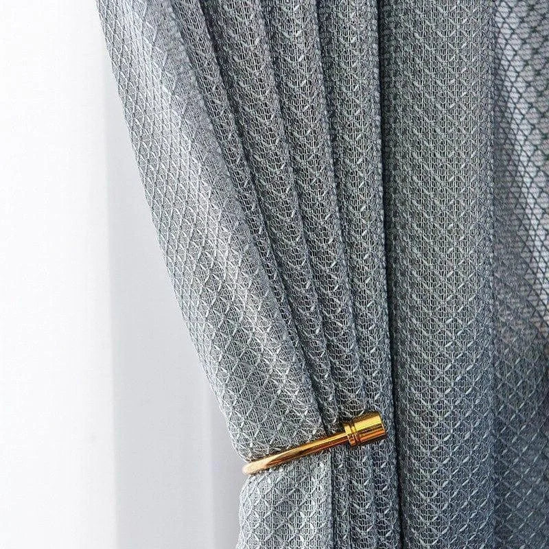 Rideau gris élégant avec motif géométrique, retenu par un embrasse dorée, idéal pour ajouter une touche contemporaine à votre décoration intérieure. Parfait pour le salon, la chambre ou le bureau.