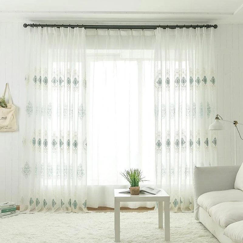 Photo d'un séjour lumineux avec rideaux élégants, ornés de motifs décoratifs subtils. Le salon inclut un canapé confortable et une table basse moderne, créant une ambiance accueillante et apaisante. Idéal pour ceux qui souhaitent ajouter une touche de sophistication à leur décoration intérieure.