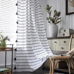 Rideau décoratif blanc à motifs noirs disposé dans un salon lumineux avec un meuble en bois et des plantes vertes, créant une ambiance élégante et moderne. Parfait pour apporter une touche de style épuré à votre intérieur.