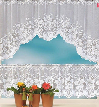 Rideau décoratif blanc avec motifs floraux élégants, parfait pour embellir une fenêtre de cuisine. Ce modèle ajoute une touche de charme et de luminosité à votre intérieur tout en préservant votre intimité. Accordé avec des plantes en pot disposées sur le rebord de la fenêtre, ce rideau crée une ambiance harmonieuse et accueillante.