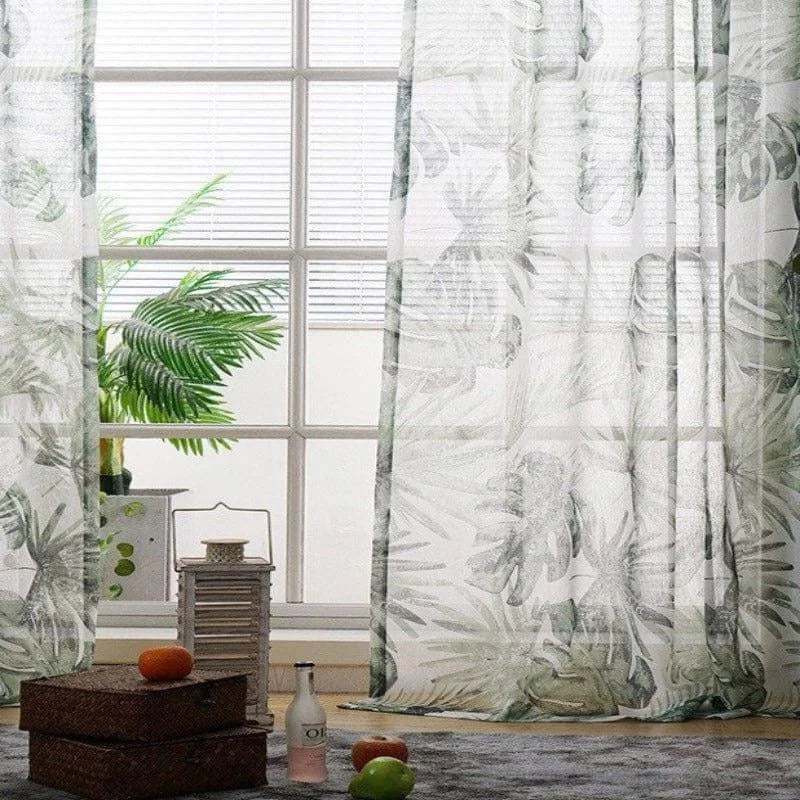 Rideau à motif feuillage vert pour salon moderne, accroché à une grande fenêtre laissant passer la lumière naturelle. Décoration intérieure avec lampe décorative, plantes et accessoires, créant une ambiance naturelle et apaisante. Accessoire idéal pour ajouter une touche de verdure et d'élégance à votre espace de vie.