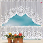 Rideau décoratif blanc avec motifs floraux élégants, parfait pour embellir une fenêtre de cuisine. Ce modèle ajoute une touche de charme et de luminosité à votre intérieur tout en préservant votre intimité. Accordé avec des plantes en pot disposées sur le rebord de la fenêtre, ce rideau crée une ambiance harmonieuse et accueillante.