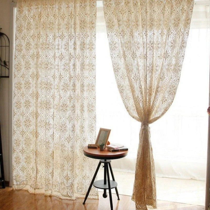 Rideau décoratif beige avec motifs floraux, apportant élégance et luminosité à la pièce, idéal pour un salon ou une chambre moderne. Table d'appoint ronde en bois avec cadre photo et livres posés dessus, ajoutant une touche de chaleur et de convivialité à l'ensemble du décor intérieur.